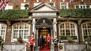 Der Eingang des Goring Hotel mit einer traditionellen Fassade, einem Wappen und einem roten Teppich, der zum Eingang führt.