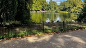 A park with a lake, trees, and a fence. - Buckingham Palace 4BR Family Stay Cathedral View (London)