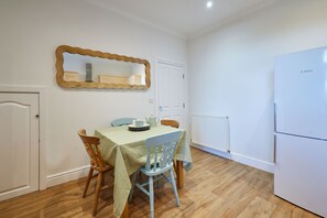 A dining area with a table, chairs, a mirror, and a white refrigerator. - Host & Stay | Prospect Retreat (Knaresborough)