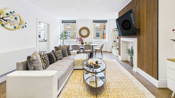 Un salon moderne avec un canapé, une table basse et des œuvres d’art décoratives au mur.