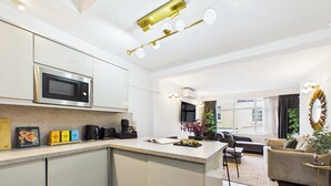 A modern kitchen with a central island, built-in microwave, and coffee maker. - Elegant Marylebone Mews Apartment (Greater London)