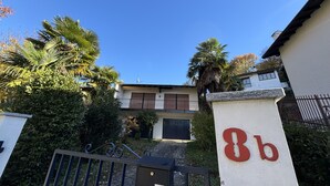 A residential building with a gated entrance, a balcony, and a sign with the number "8b". - Carmen apartment with lake view and balcony (Luino)