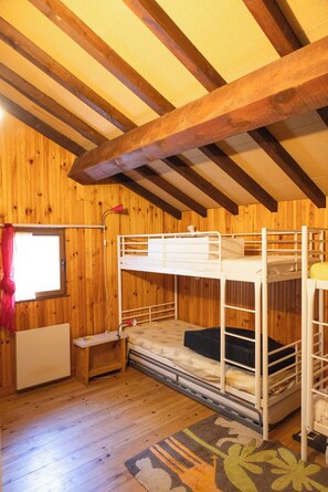 A wooden-paneled room with bunk beds, a window with curtains, and a radiator. - Caza Audelou *T5 * Panoramic view of the lake and valley * Fireplace * Parking * (Réal)