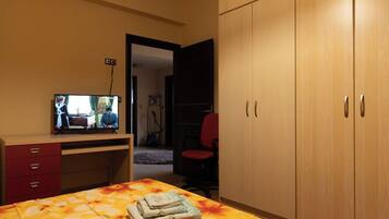Bedroom with Ample Storage and TV
Functional bedroom featuring a large wardrobe, warm tones, and a TV for added convenience and entertainment.
