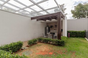 Un patio couvert comprenant une cuisine et un espace salon.