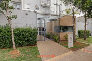 Un bâtiment moderne doté d’une entrée en verre, d’une façade en bois et d’une enseigne indiquant le numéro 220.