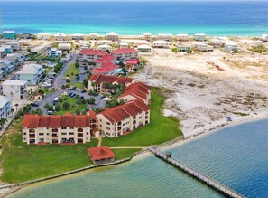 Ein Hotel an der Küste mit mehreren Gebäuden, einem Strand und einem Steg.