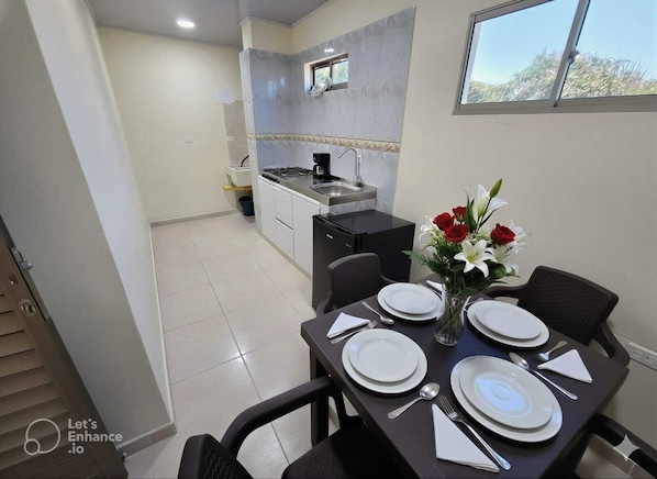 A compact kitchen with a small dining area set for two.