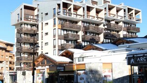 A multi-story hotel with balconies and a ski resort sign. - 7-room Apartment in Tignes Val Claret (Tignes)