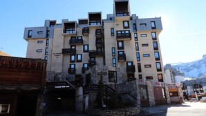 A multi-story building with balconies and a stone entrance. - 7-room Apartment in Tignes Val Claret (Tignes)