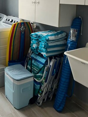 A bathroom with a white sink, a blue shower curtain, and a stack of folded towels. - 3-Bedroom Beachside Penthouse in delightful Luquillo with AC @ Playa Azul Beach (Luquillo)