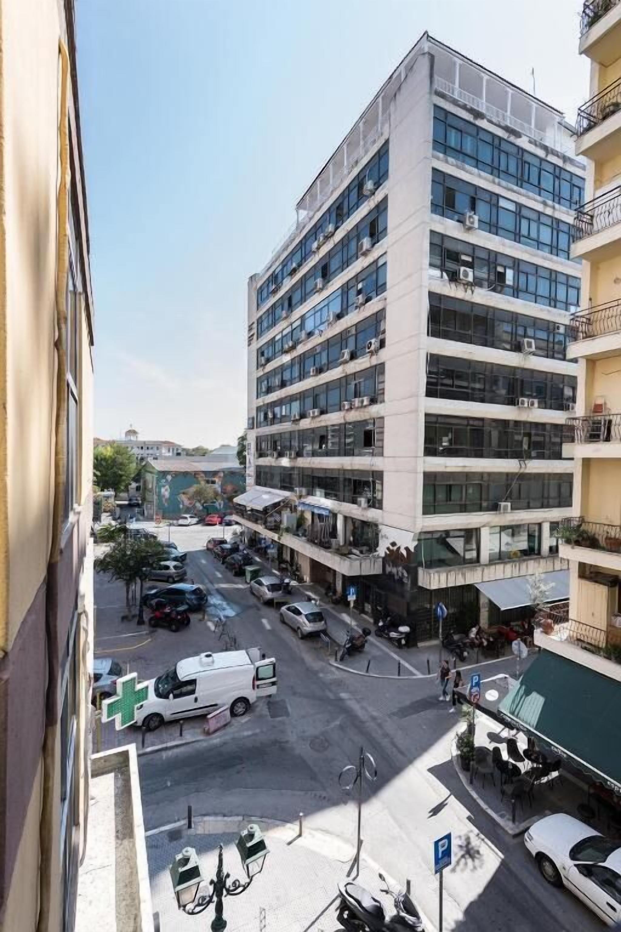 A multi-story building with a parking lot in front.