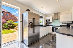 Una cocina moderna con un refrigerador de acero inoxidable, horno empotrado y microondas.
