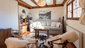 A cozy living room with a sofa, coffee table, and bookshelves.