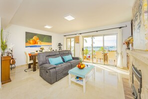 Ein Wohnzimmer mit grauem Sofa, einem Couchtisch und einem Gemälde an der Wand.