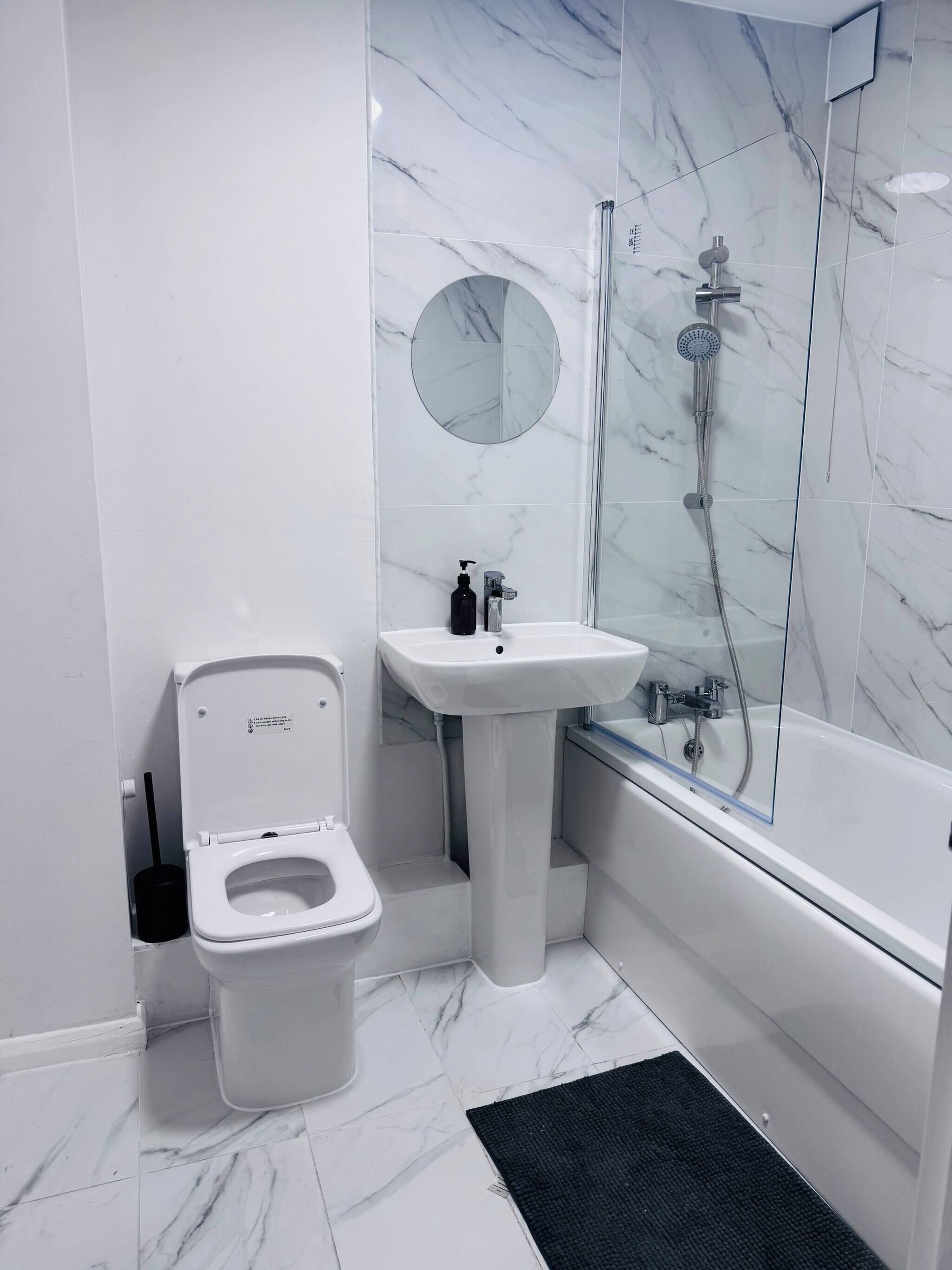 A modern bathroom with a toilet, sink, and shower.