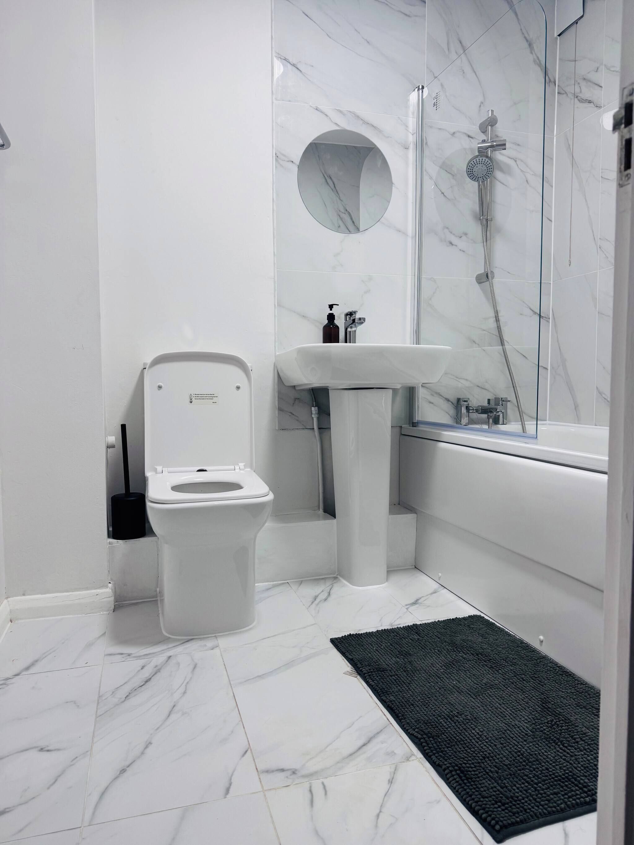 A modern bathroom with a toilet, sink, and shower.