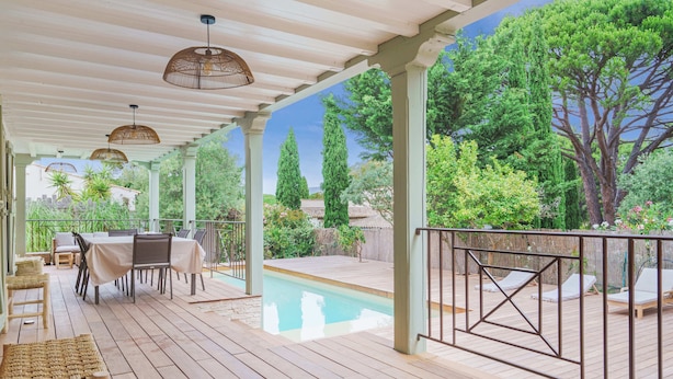 A covered outdoor area with a pool, wooden deck, and seating arrangements. - Douceur de vivre tropezienne: renovated house near beach and village (Gassin)