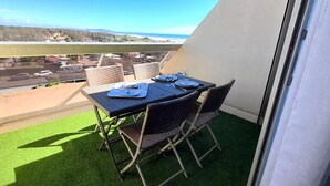Un balcón con una mesa para dos, con vistas a la costa.