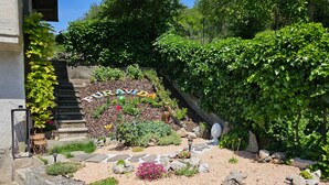 Un jardin avec un chemin de pierres, une statue et un panneau sur lequel on peut lire « PURA VIDA ».