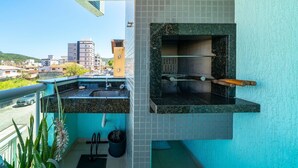 Un balcone con angolo cottura, dotato di lavello e barbecue integrato, con vista su una zona residenziale.