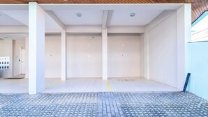 Un ambiente interno vuoto con pavimento piastrellato, pareti bianche e soffitto in legno.