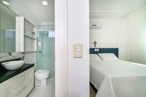 Een badkamer met een wastafel, toilet en douchecabine met glazen wanden.
