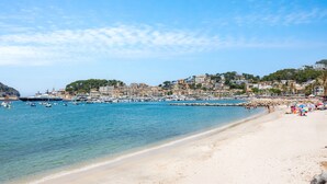 A coastal beach with clear waters, a sandy shore, and buildings in the background. - Marina 48 Apartment on the Seafront with Sea Views, Wi-Fi and Air Conditioning (Port de Sóller)