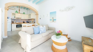 A modern kitchen with white cabinets, a tiled backsplash, and a hanging light fixture. - Marina 48 Apartment on the Seafront with Sea Views, Wi-Fi and Air Conditioning (Port de Sóller)