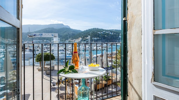 A balcony with a table, chairs, and a view of a marina and mountains. - Marina 48 Apartment on the Seafront with Sea Views, Wi-Fi and Air Conditioning (Port de Sóller)