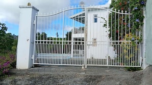 Une propriétéClose, avec un bâtiment blanc, un portail en métal et un petit balcon.