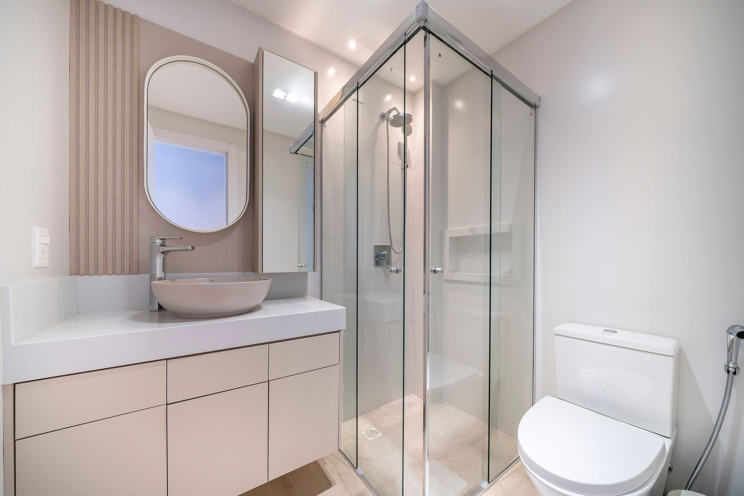 Une salle de bain moderne avec une douche à parois de verre, un lavabo blanc et des toilettes.