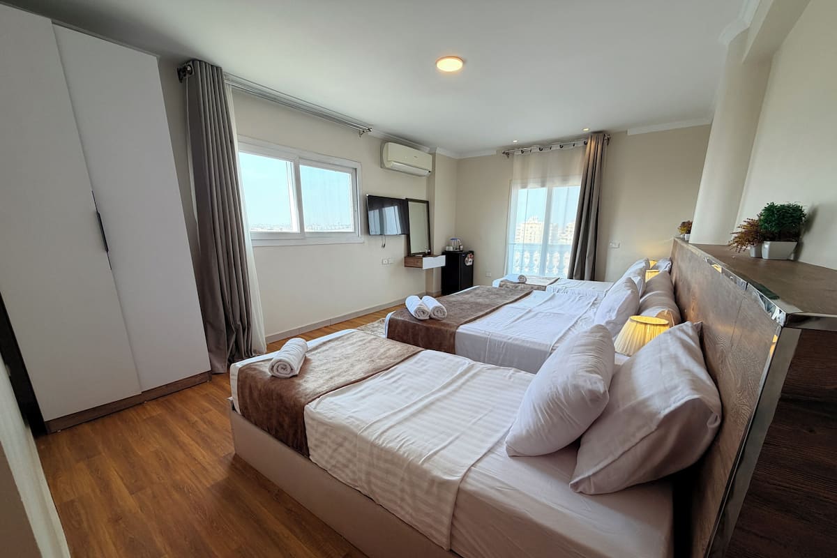 Habitación triple Deluxe, vista a la montaña | Espacio para trabajar con laptop, cortinas blackout y insonorización