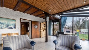 A living room with striped sofas, a wooden ceiling, and a large window. - Panorama Holiday Home Sorpesee, 120 sqm, Lake View, Private Terrace & Wi-Fi (Sundern)