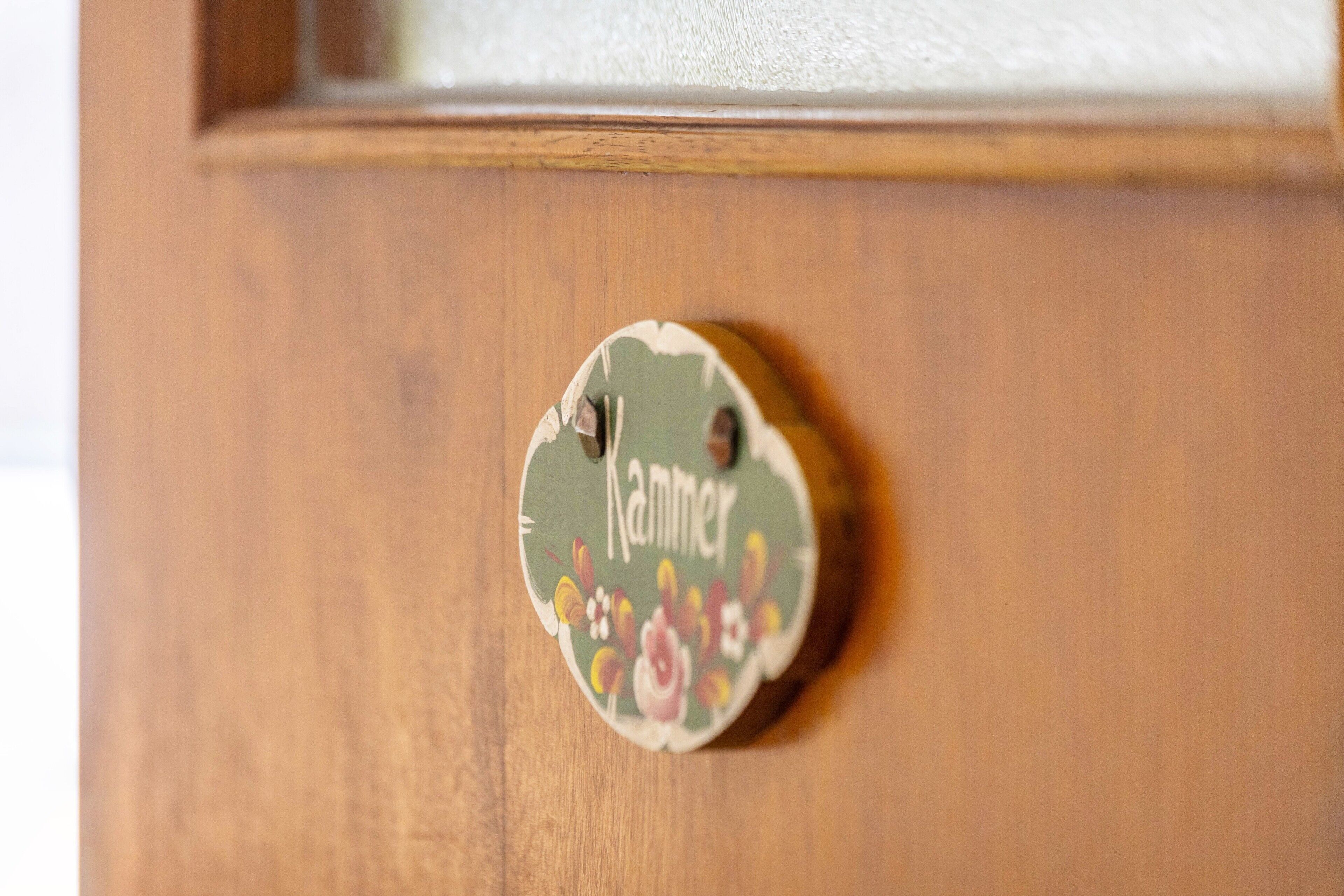 A wooden door with a circular handle and a decorative label.