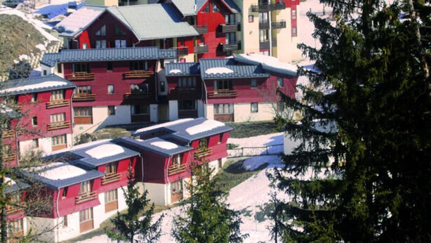 A cluster of red buildings with multiple balconies, likely part of a hotel or resort. - 2-room Duplex Apartment for 4 People With Balcony - Val-cenis Le Haut (Val-Cenis)