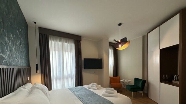 A modern hotel room with a large bed, a desk, a chair, and a TV. - Cozy and spacious suite near Vatican with private bathroom (Room 3) (Roma)