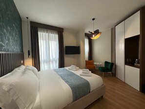 A modern hotel room with a large bed, a desk, a chair, and a TV. - Cozy and spacious suite near the Vatican with a private bathroom (Room 3) (Roma)