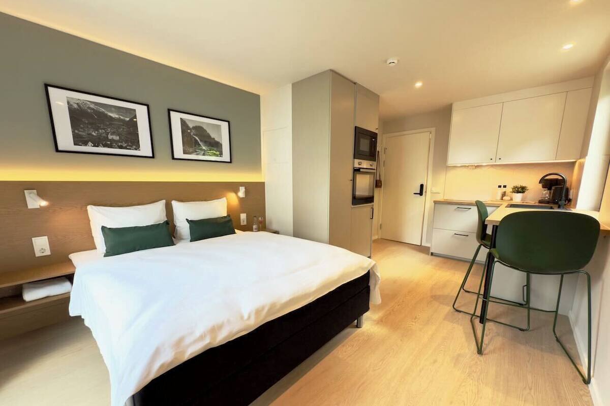 Une chambre d’hôtel avec un lit, un bureau et une kitchenette.