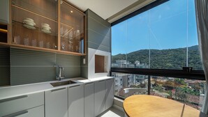Une cuisine moderne dotée d’une grande fenêtre, d’un coin repas et offrant une vue sur le paysage urbain.