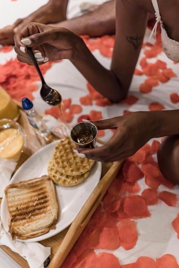 A tray with waffles, a grilled sandwich, and a small bowl of syrup.