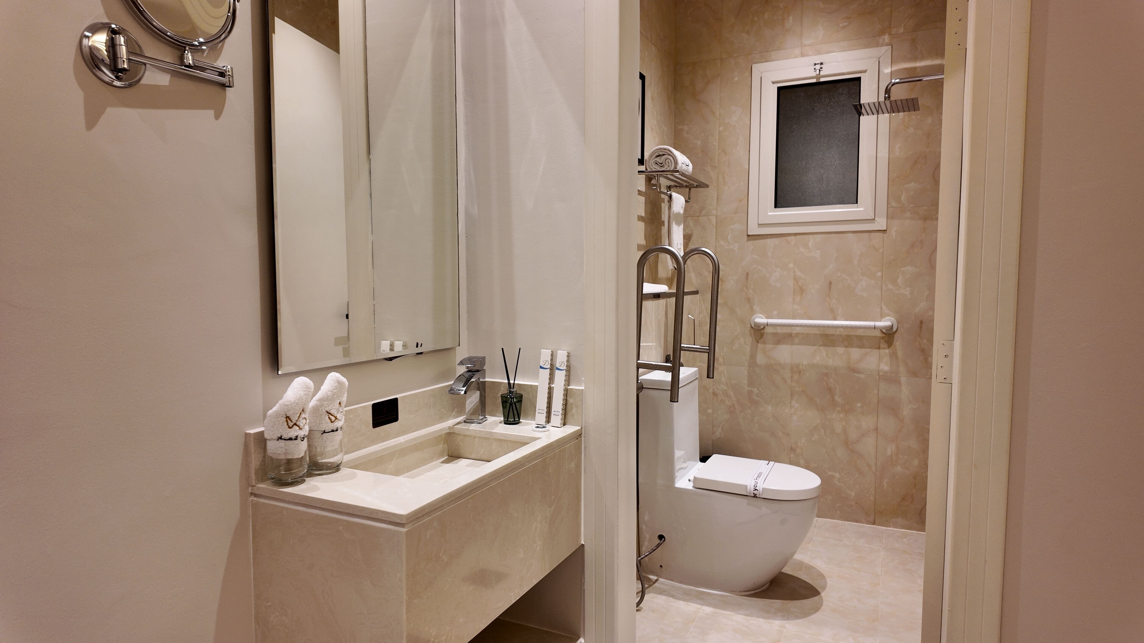 Een moderne badkamer met een wastafel, wastafelblad, spiegel en toilet.