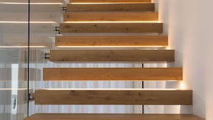 A modern staircase with wooden steps and glass railings. - Luxury Villa Neptune (Palermo)