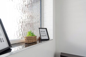 A framed sign with the text 'RELAX SOAK unwind' on a windowsill with a plant. - Toast Stays - Towngate Terrace (Darlington)