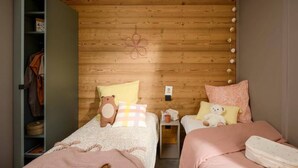 A cozy bedroom with two beds, wooden headboard, and a small bedside table with a lamp. - Chalet in Aussois With Stunning Mountain Views (Aussois)