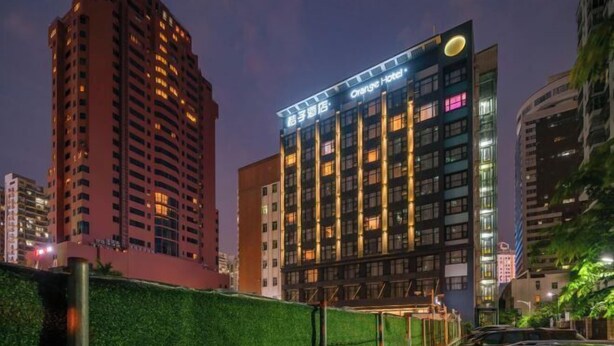 Et hotel med et moderne design, der har en tydelig skiltning og flere etager.