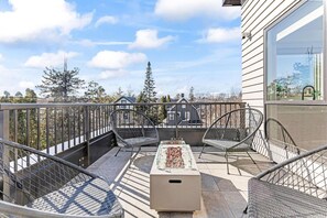 A balcony with two metal chairs, a glass-top table, and a rectangular planter. - Cozy 2BR Retreat w/ Gym & Roofdeck near Downtown (Minneapolis)