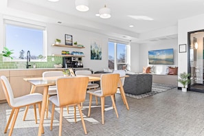 A modern kitchen with a dining area, large windows, and a view of the outdoors. - Cozy 2BR Retreat w/ Gym & Roofdeck near Downtown (Minneapolis)
