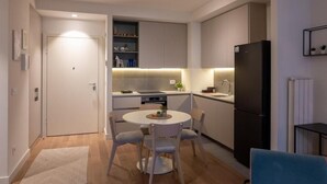 A compact kitchen with a dining area, a refrigerator, and a small table with chairs. - Belgrade Waterfront Lux  (Belgrade)