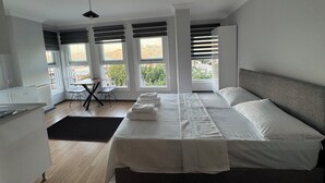 A modern bedroom with a large bed, a desk, and a chair. - Disa Elite istanbul  (Istanbul)